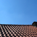 Een plaatje van een dak met een mooie blauwe lucht